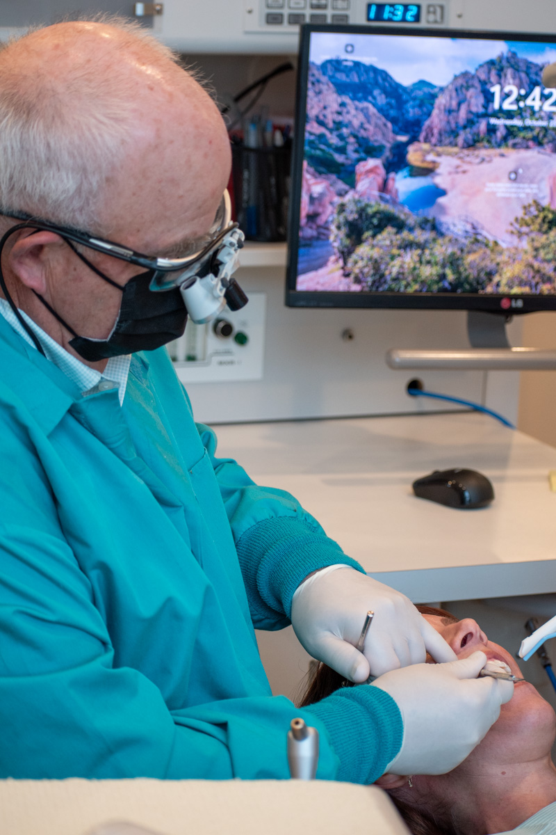 Dentist performing procedure with loupes
